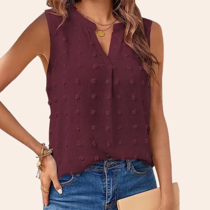 Elegante camicetta da donna senza maniche con motivo a pois di tendenza e attraente scollatura a V